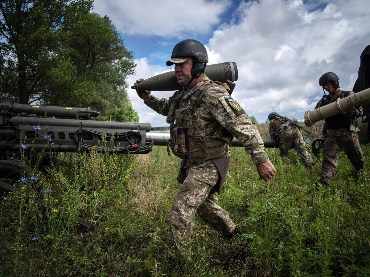    Ukrajinský vojak so 155 mm granátom © AP Photo / Evgeniy Maloletka
